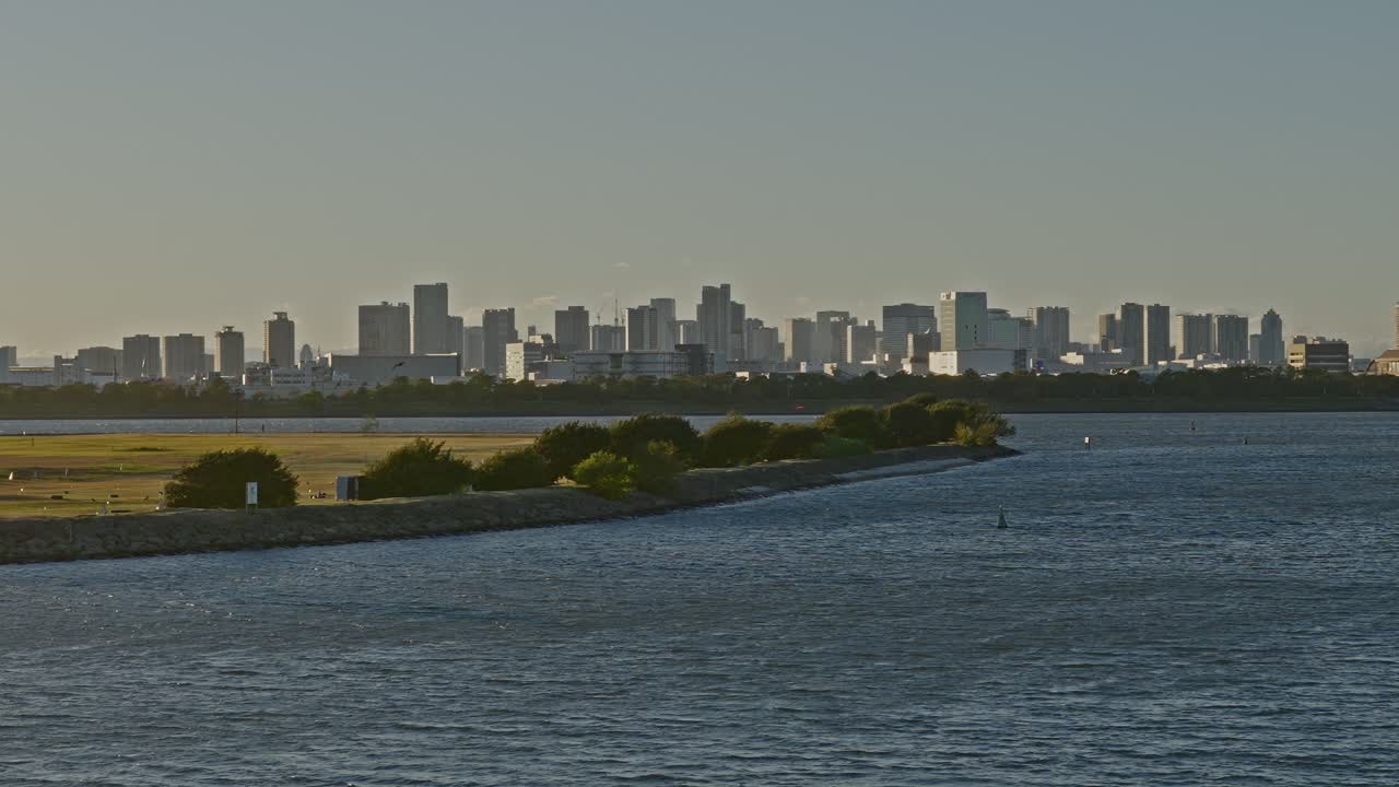 A zoomed-in view of a dense, modern cityscape with high-rise buildings separated from the foreground by a body of water