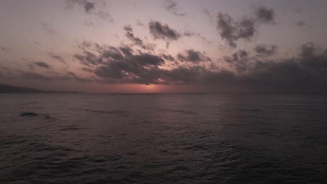 aerial view flying above dramatic calming rocky coastal beach horizon