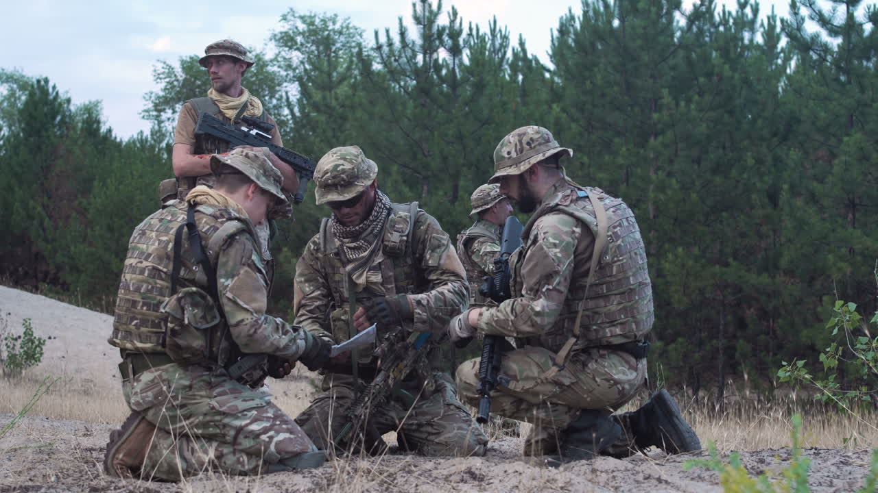 Military Personnel Studying Map in the Field
