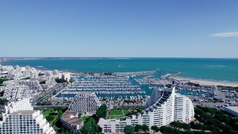 Aerial-view-of-large-marina-of-with-pyramid-buildings-during-sunny-day-with-blue-sky-in-La-Grande-Motte