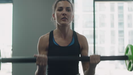 woman lifting barbell in gym