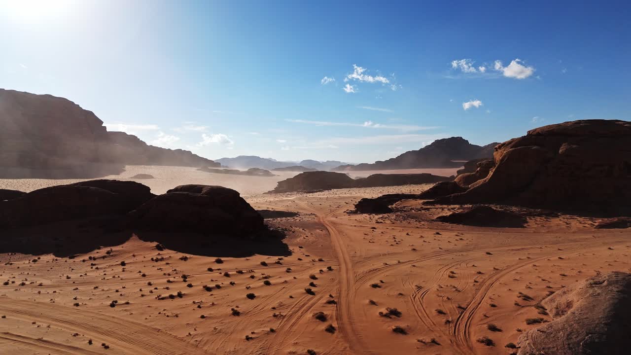 Un’immagine aerea mozzafiato che cattura una tempesta di sabbia locale o un diavolo di sabbia che si muove attraverso la vasta valle desertica di Wadi Rum in una giornata di sole.