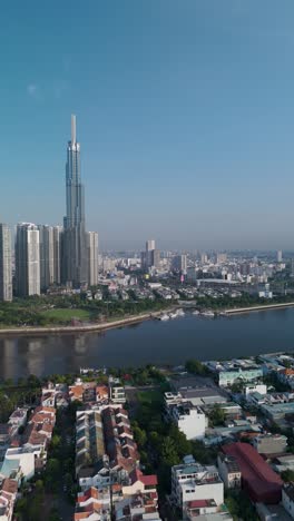 landmark building on the saigon river panning reveal with clear blue sky vertical drone