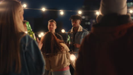 un grupo feliz de amigos bailando juntos disfrutando de la música de la fiesta en la azotea por la noche divirtiéndose bebiendo alcohol celebrando la reunión de fin de semana
