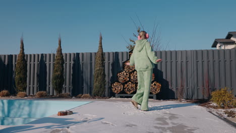 woman dancing in a winter garden near a swimming pool