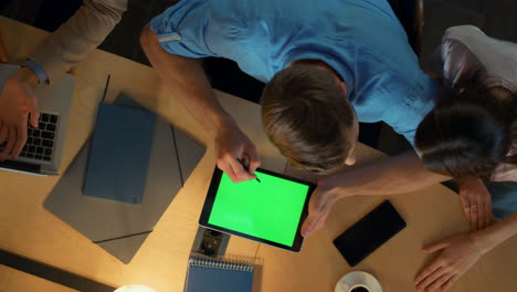 Man-using-stylus-on-tablet-indoors.-Busy-team-discussing-work-issues-in-office.