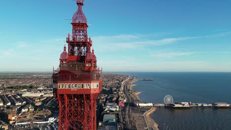 Vuelo-Aéreo-De-Drones-Junto-A-La-Torre-De-Blackpool-Y-La-Costa-Mostrando-Los-Muelles-Y-La-Playa-De-Placer-En-La-Distancia