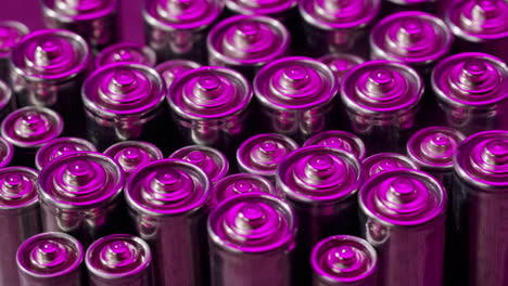 silver batteries aa and aaa in neon light close-up. double-a battery is a standard size single cell cylindrical dry battery. batteries are common in portable electronic devices. an aa battery is composed of a single electrochemical cell that may be either a primary battery or a rechargeable battery.