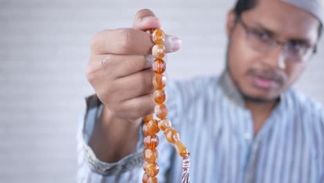 muslim man holding prayer beads