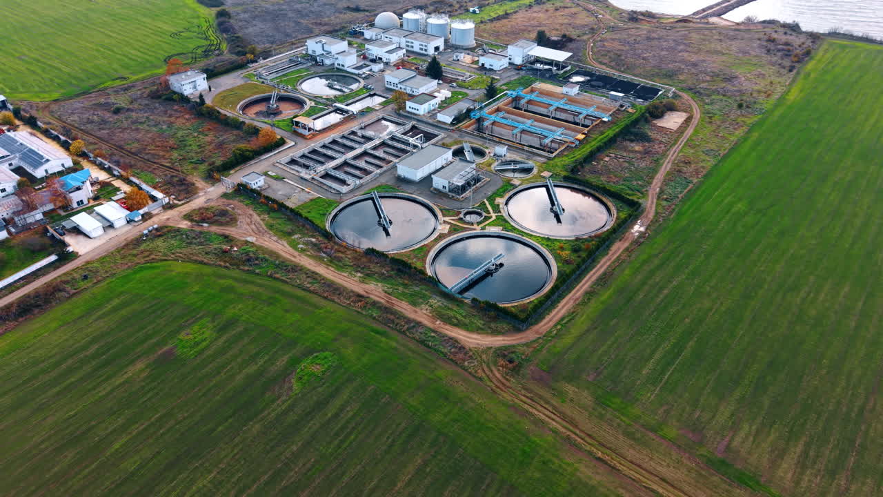 Distancing from the facility for wastewater filtration and chemical processes to meet health and safety standards. Sewage treatment plant in the fields