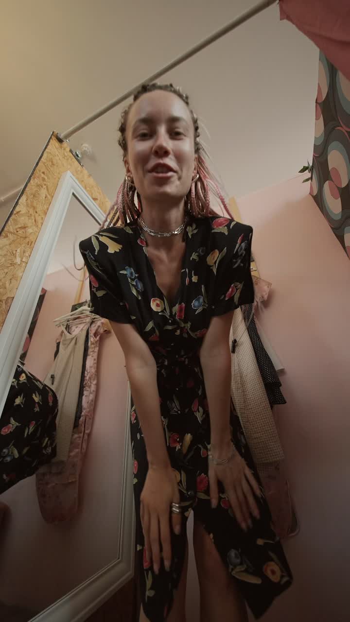 Woman in a floral vintage dress trying it on in a mirror