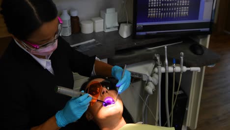 Female-dentist-examining-a-patient-with-tools-4k