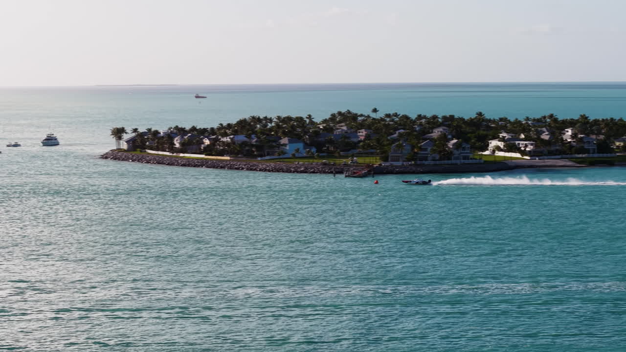 Drone tracking a superboat driving on the coast of Key West, sunny Florida, USA