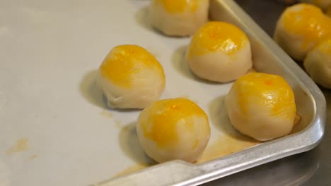 Hand-Put-Baked-Chinese-Pastry-on-Tray,-Close-Up-3