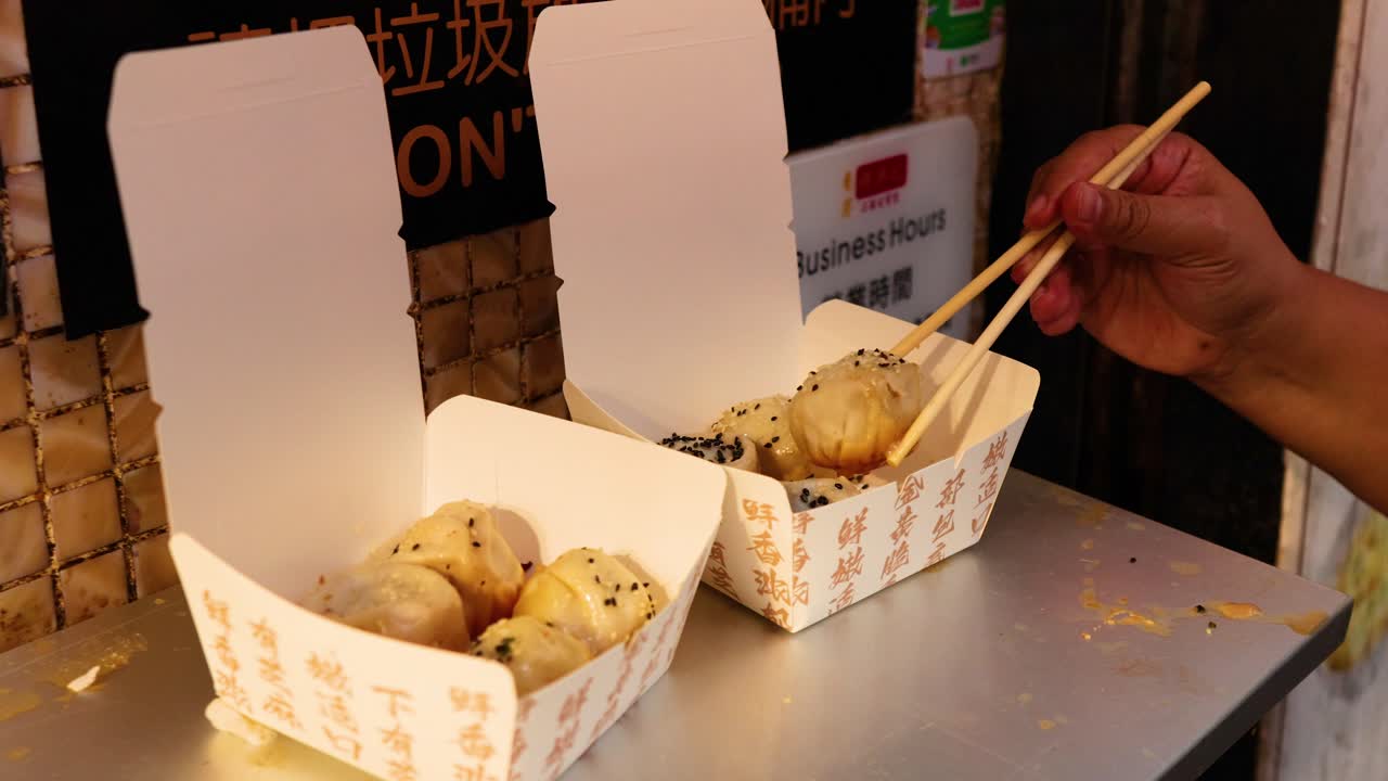 Chopsticks picking buns from takeaway boxes