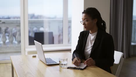 Afroamerikanische-Sekretärin,-Geschäftsfrau,-Die-Am-Tisch-Im-Büro-Sitzt