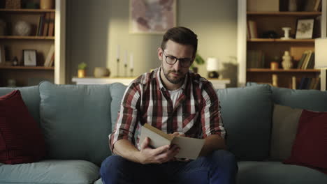 Man reading a book on the couch