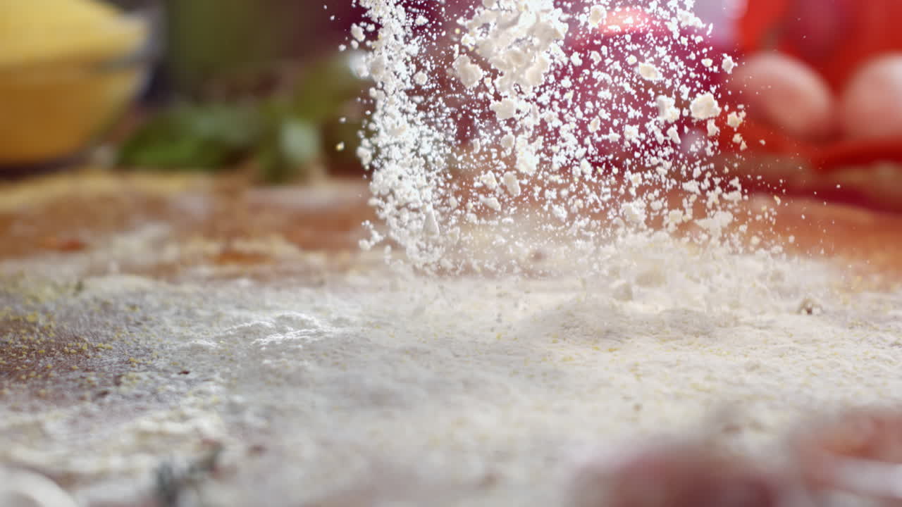 Flour falling onto a wooden table for baking