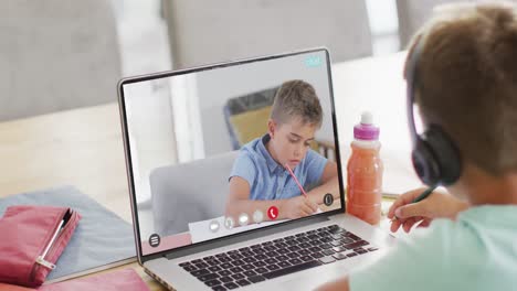 Caucasian-schoolboy-having-class-on-laptop-video-call-with-his-friend-in-slow-motion