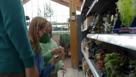 madre con niños eligiendo artículos de decoración de acuario en la tienda