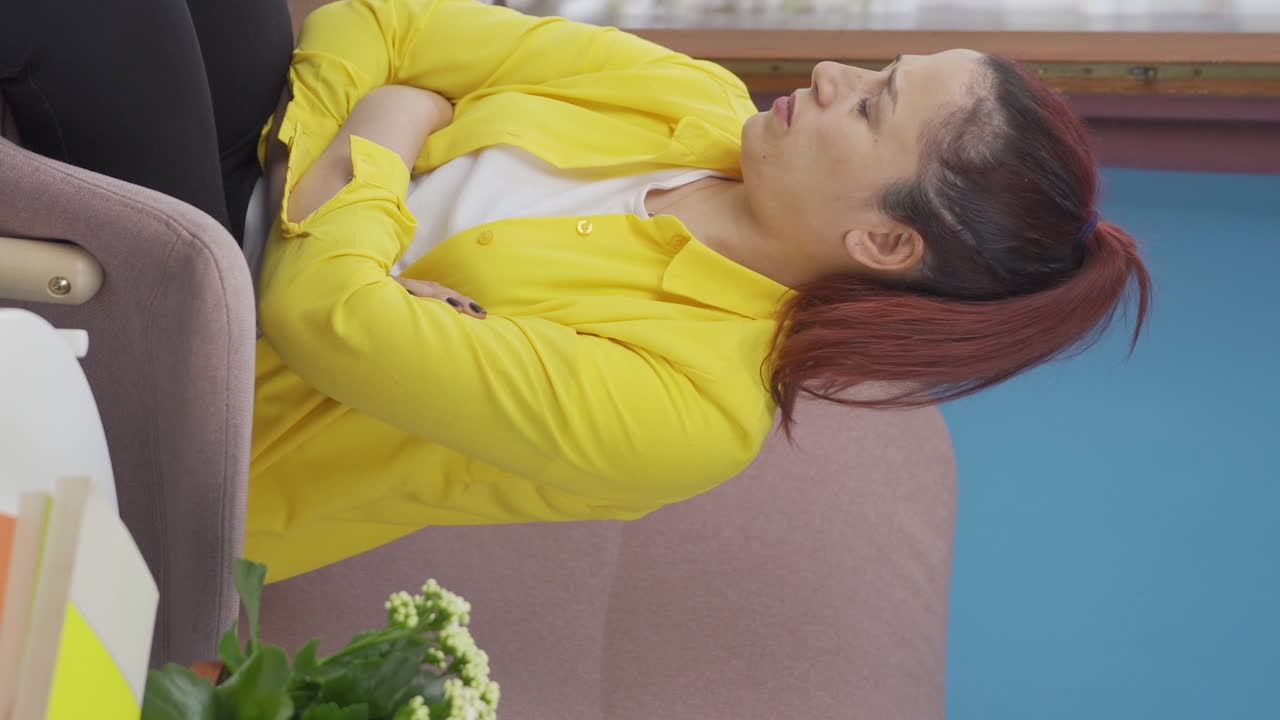 우울증에 걸린 여성의 수직 비디오. 여성은 창문 밖을 보고 있습니다.