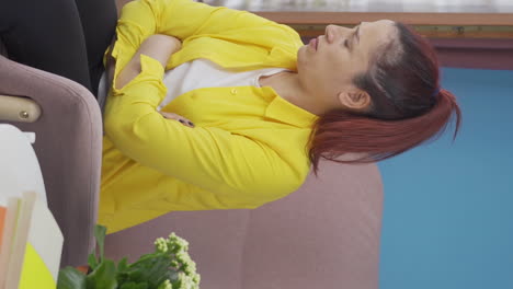vertical video of depressed woman. the woman is watching out the window.