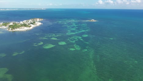 Aerial-view-of-the-Florida-Keys,-capturing-the-vibrant-blue-and-green-waters-with-visible-marine-patterns-and-textures