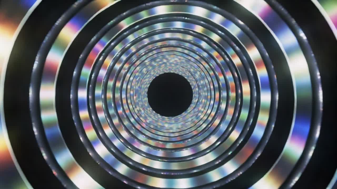 Luce che si sposta causando anelli concentrici che mostrano sfaccettature attorno a un foro scuro centrale all'interno di un tubo, arcobaleni
