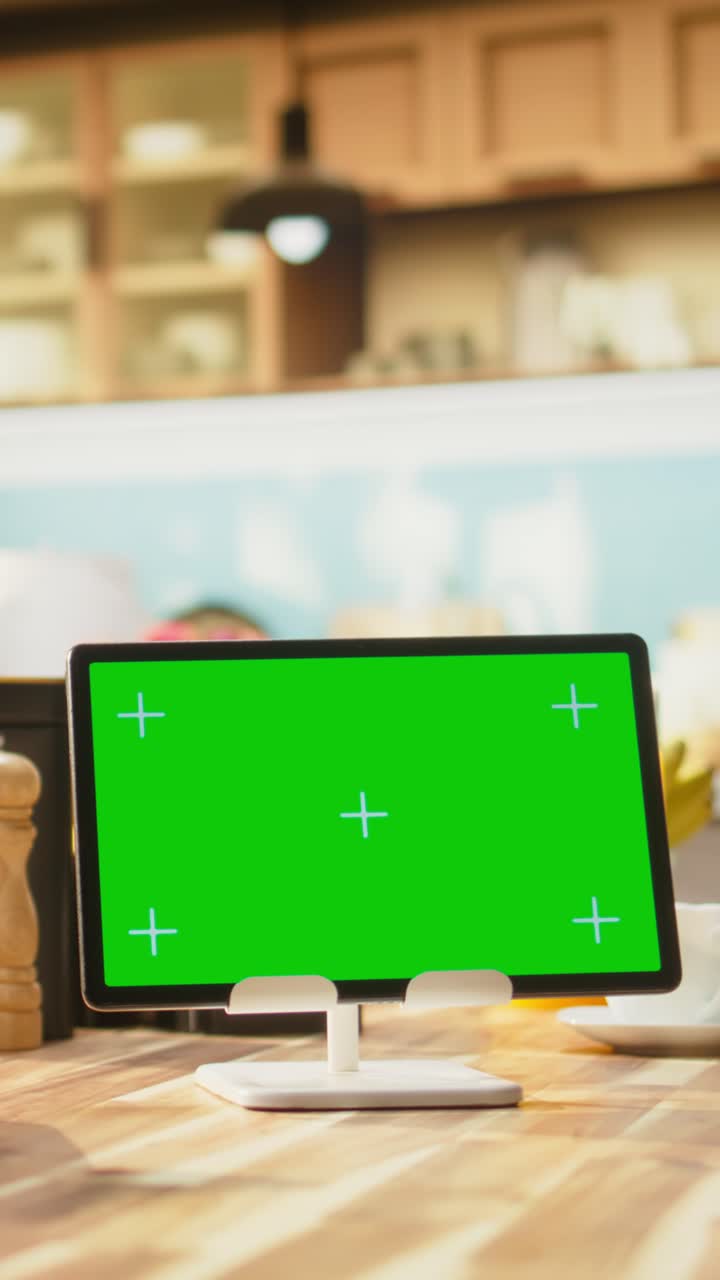 Vertical Video Green screen on tablet in kitchen interior design with empty wooden table