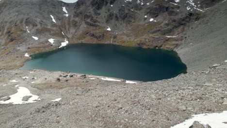 Spektakuläre-Drohnenansicht-über-Den-Felsen-Eines-Hochgelegenen-Alpensees-In-Den-Neuseeländischen-Bergen,-Landschaft