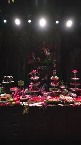 a table decorated with flowers contains different dessert plates, wide shot
