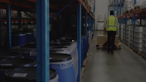 animation of connected icons over african american worker moving cardboard boxes with trolley