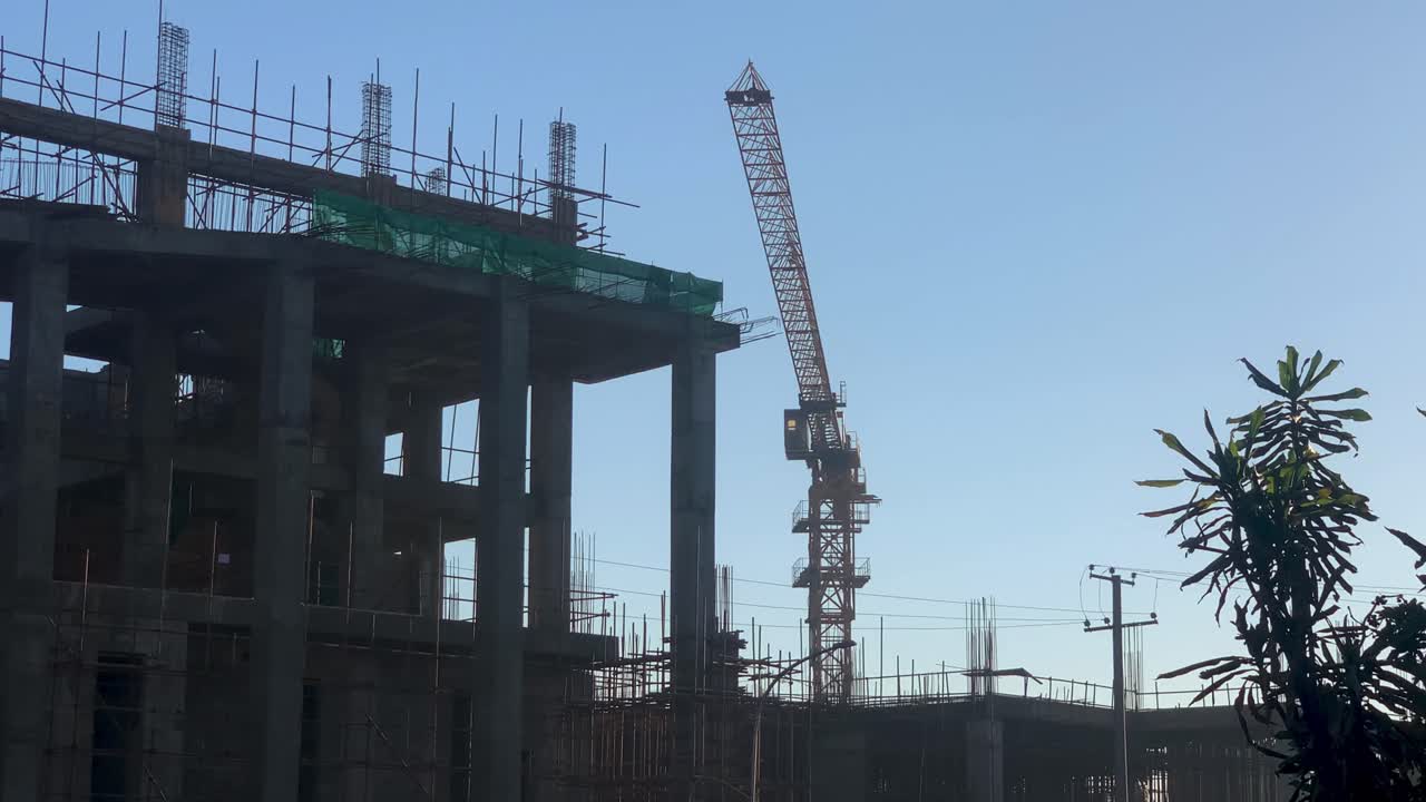 grúa moviéndose detrás del edificio de construcción, en piassa