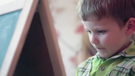 little-boy-in-green-shirt-holds-colorful-felt-tip-pen