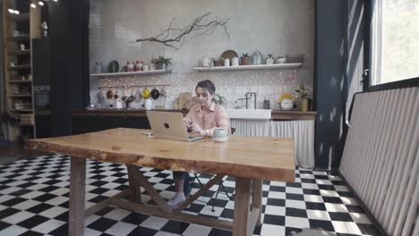 mujer trabajando en una computadora portátil en una cocina moderna