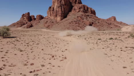dust cloud on a desert track amidst rocky mountains