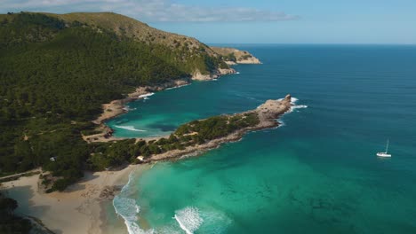 Natürliche-Sandstrandbucht-Mit-Klarem-Türkisblauem-Meerwasser,-Weißem-Sand-Und-Grünen-Hügeln