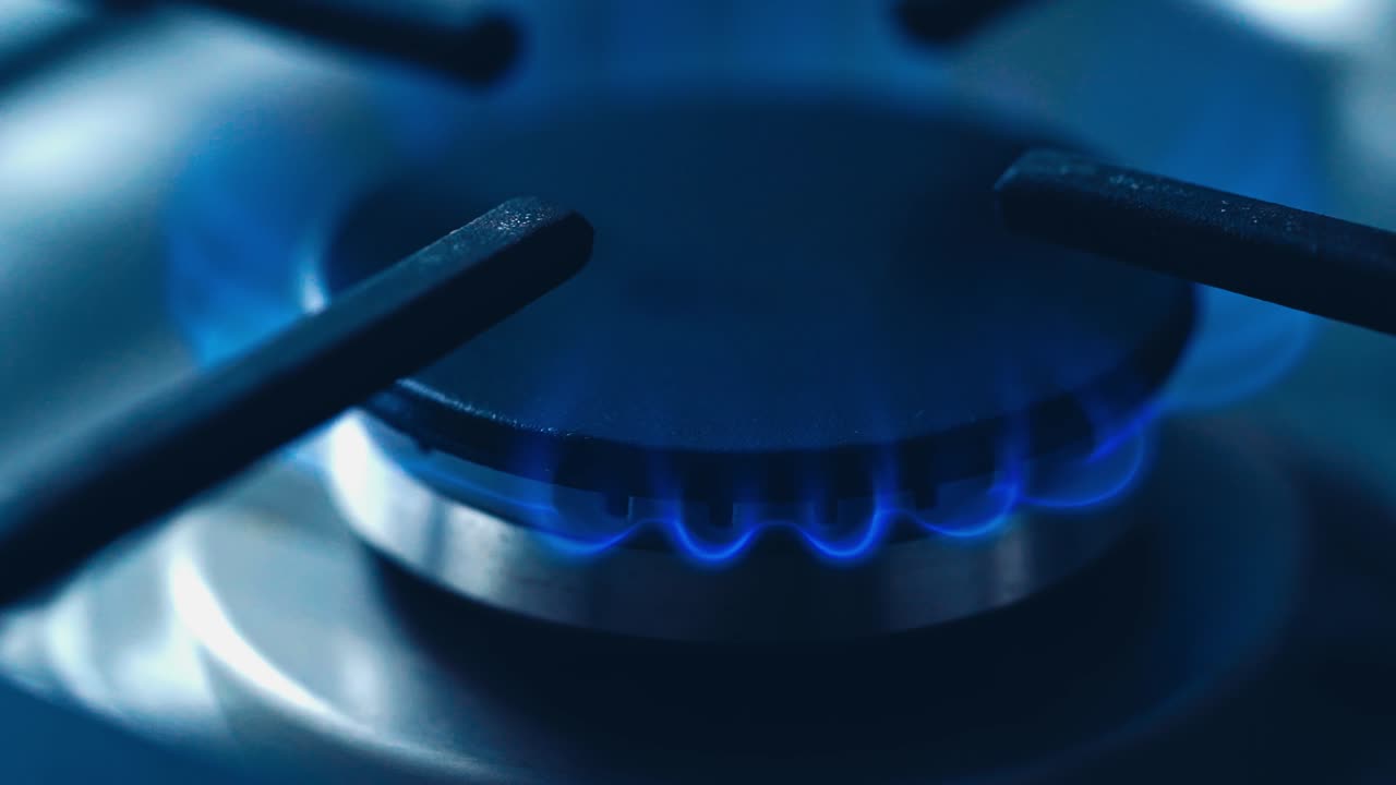 Natural gas kitchen cooker turn on and recently used. Blue and really hot flames on a gas stove. Homemade cooking concept. Circle gas hob burning ready to be use. Natural gas inflammation, close up.