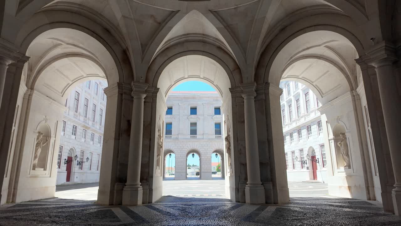 Majestic symmetry of a historic courtyard archway bathed in natural sunlight. Tilt Down