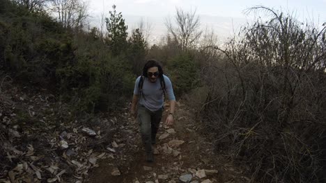 man walking to the camera, on a mountain track in forest