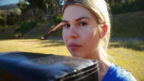 portrait of teenage girl holding boxing equipment during obstacle course