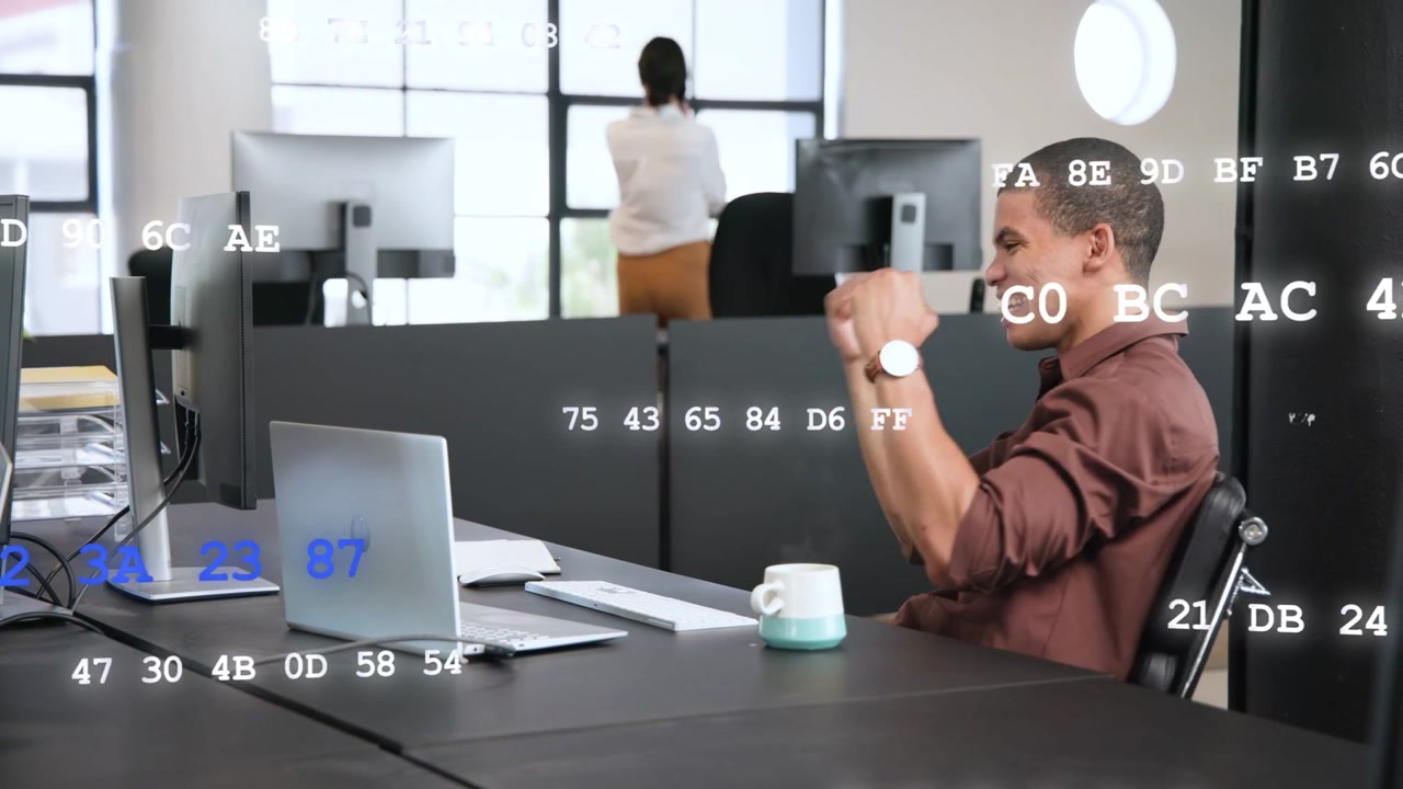 Mann am Schreibtisch sieht Erfolgsmeldung, tippt und jubelt, während Code-Grafiken über dem Technologiebüro schweben.