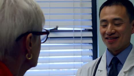 young asian male doctor interacting with senior patient at clinic 4k