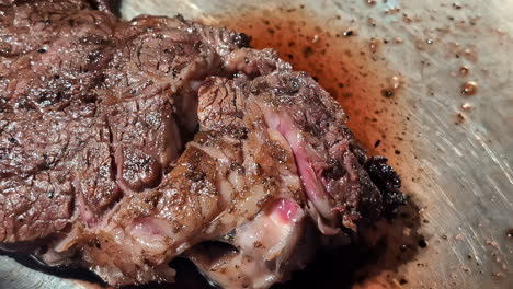 Close-up-of-slowly-moving-steak-in-a-silver-bowl