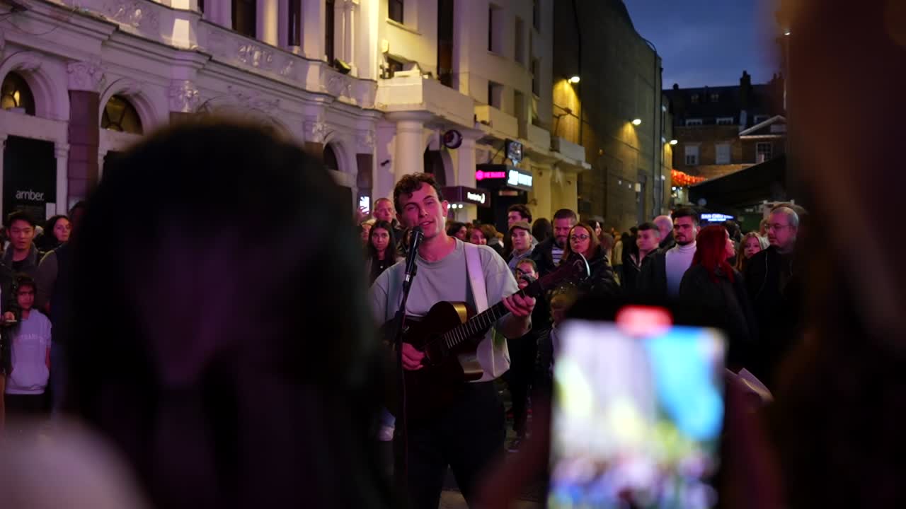 Myles Crossley sings with a smile on his face and tourists join him