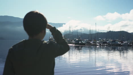 woman silhouetted as she looks out at a marina in british columbia, canada