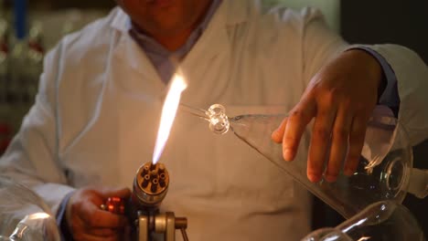 front view of mature indian male worker making wing glass in glass factory 4k