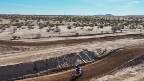 vista aérea de un motociclista dando un salto en una pista de carreras de tierra