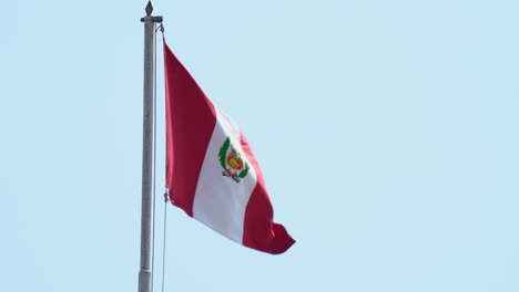 peruvian flag waving on a windy day at municipal palace in chiclayo, peru
