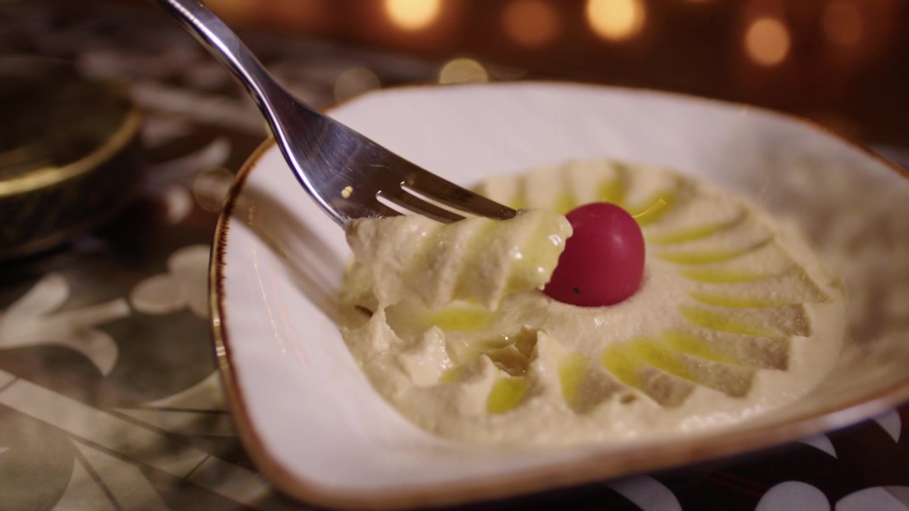 Gaffel med cremet hummus med olivenolie, en traditionel forret fra mellemøstligt køkken